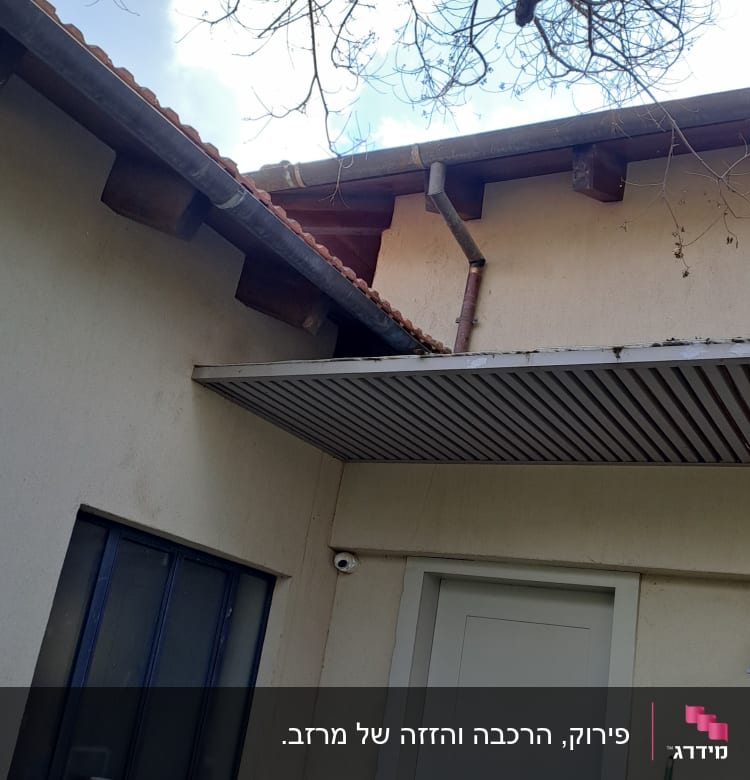 גג רעפים עם מרזב מתכת ועץ חשוף